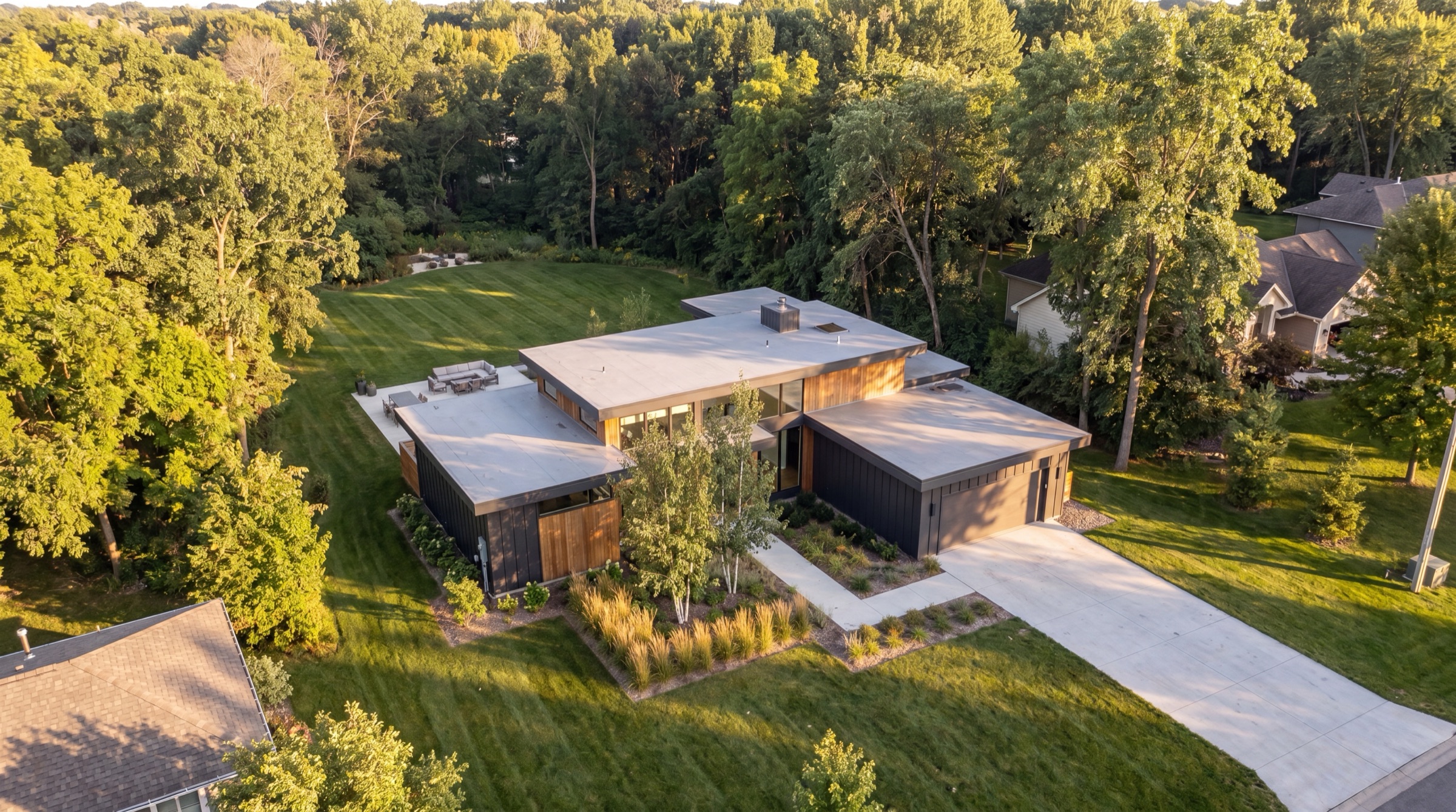 Aerial drone photo of a modern home and its wooded lot